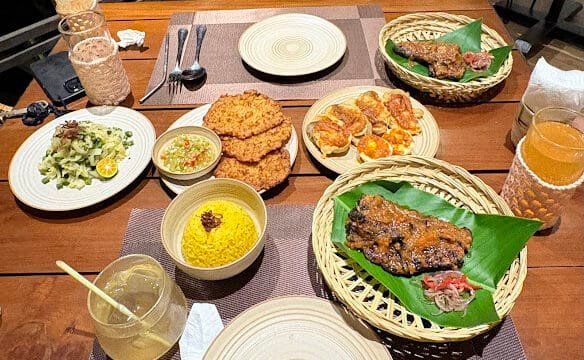 A table set with Indonesian dishes, drinks, and utensils, ready for a meal with two people inspired by Siargao’s island vibes.