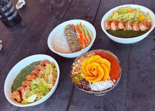Three bowls with rice, shrimp, veggies, and sauce, plus a Siargao-inspired dessert topped with a decorative yellow flower.