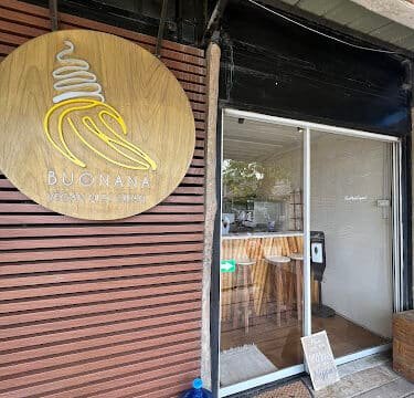 Wooden sign with ice cream logo and BUONANA outside a small Siargao shop, glass door, and water jug by the entrance.