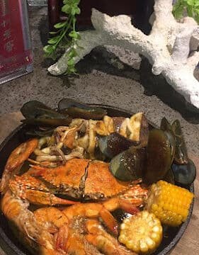 Seafood boil with crab, shrimp, mussels, corn, and mushrooms on a wooden platter—bringing Siargao’s coastal flavors to your table.