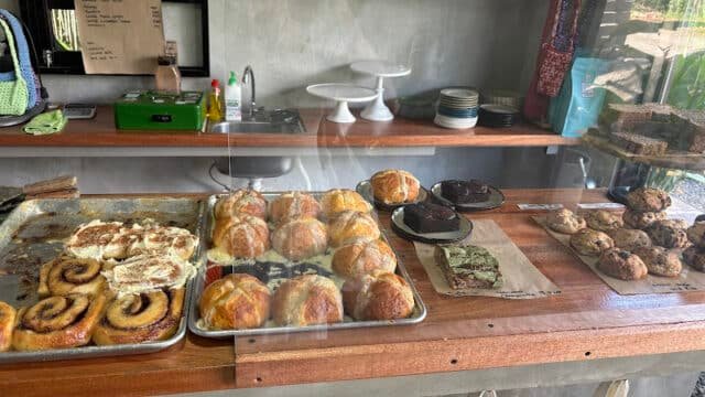 A bakery counter in Siargao displays cinnamon rolls, pastries, brownies, cookies, and other baked goods behind glass.