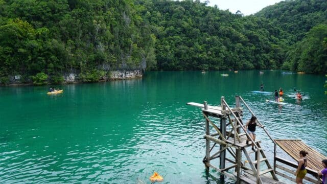 Turquoise waters of Sugba Lagoon surrounded by limestone cliffs in Del Carmen Siargao